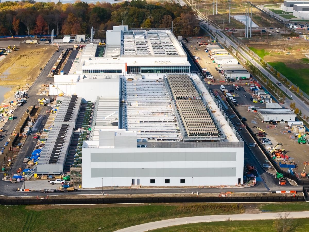 Aerial view of a large logistics and distribution facility with warehouse buildings and transport infrastructure